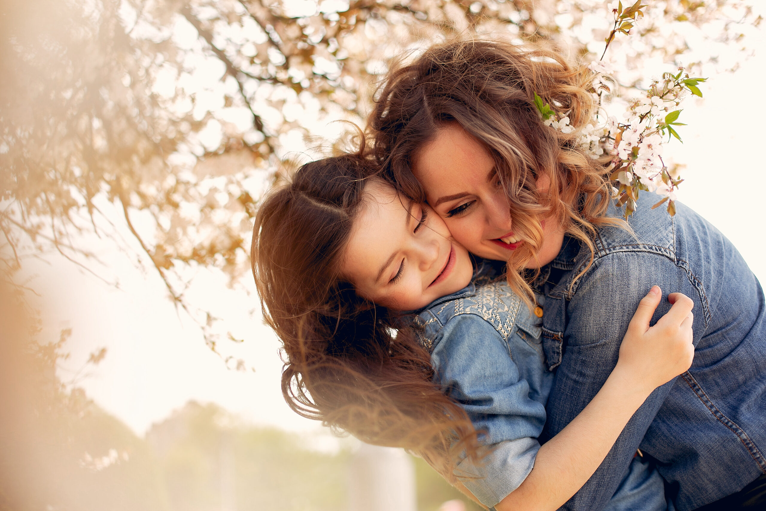 Fashionable mother with daughter. Family in a spring park. Woman in a blue shirt