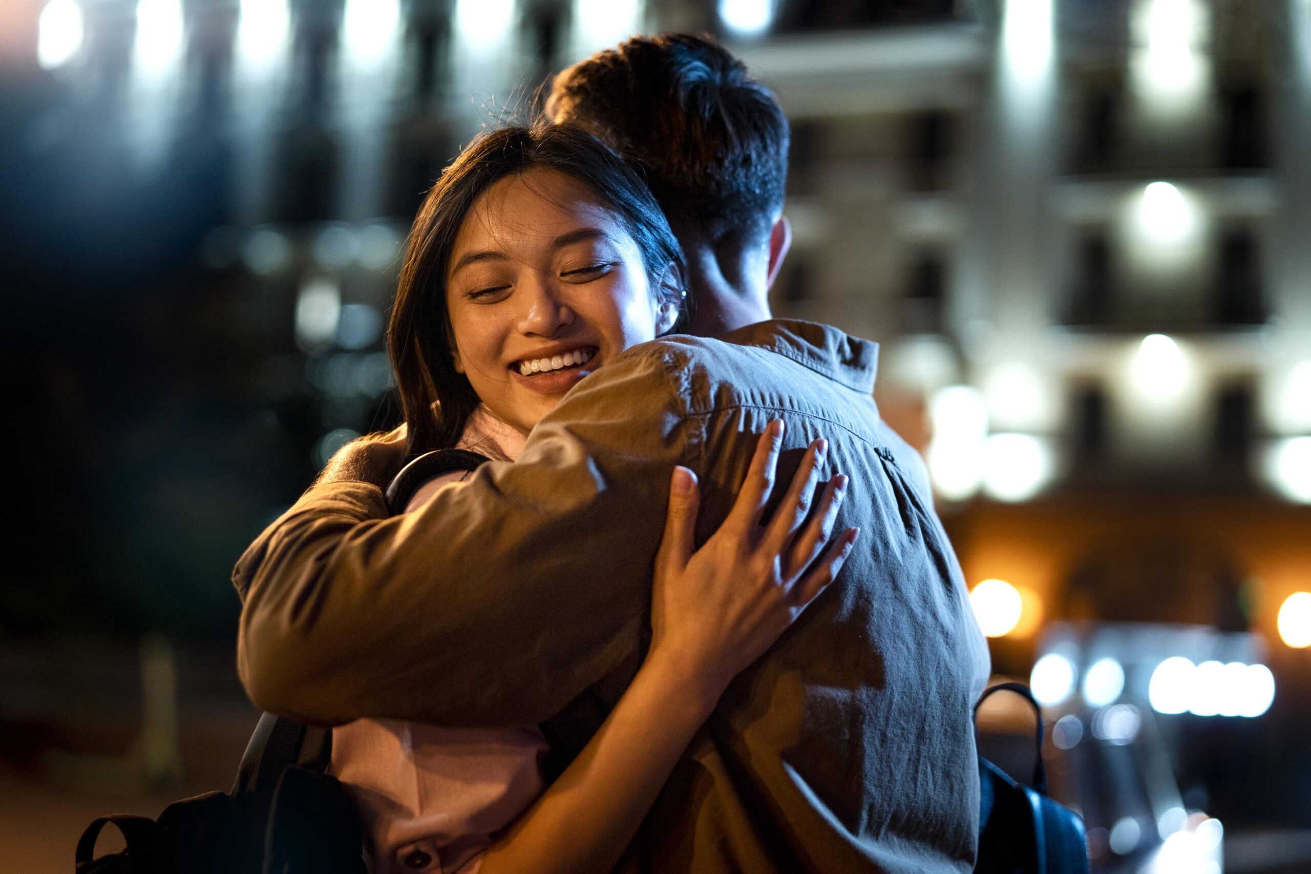 man-and-woman-hugging-at-night-in-the-city-lights