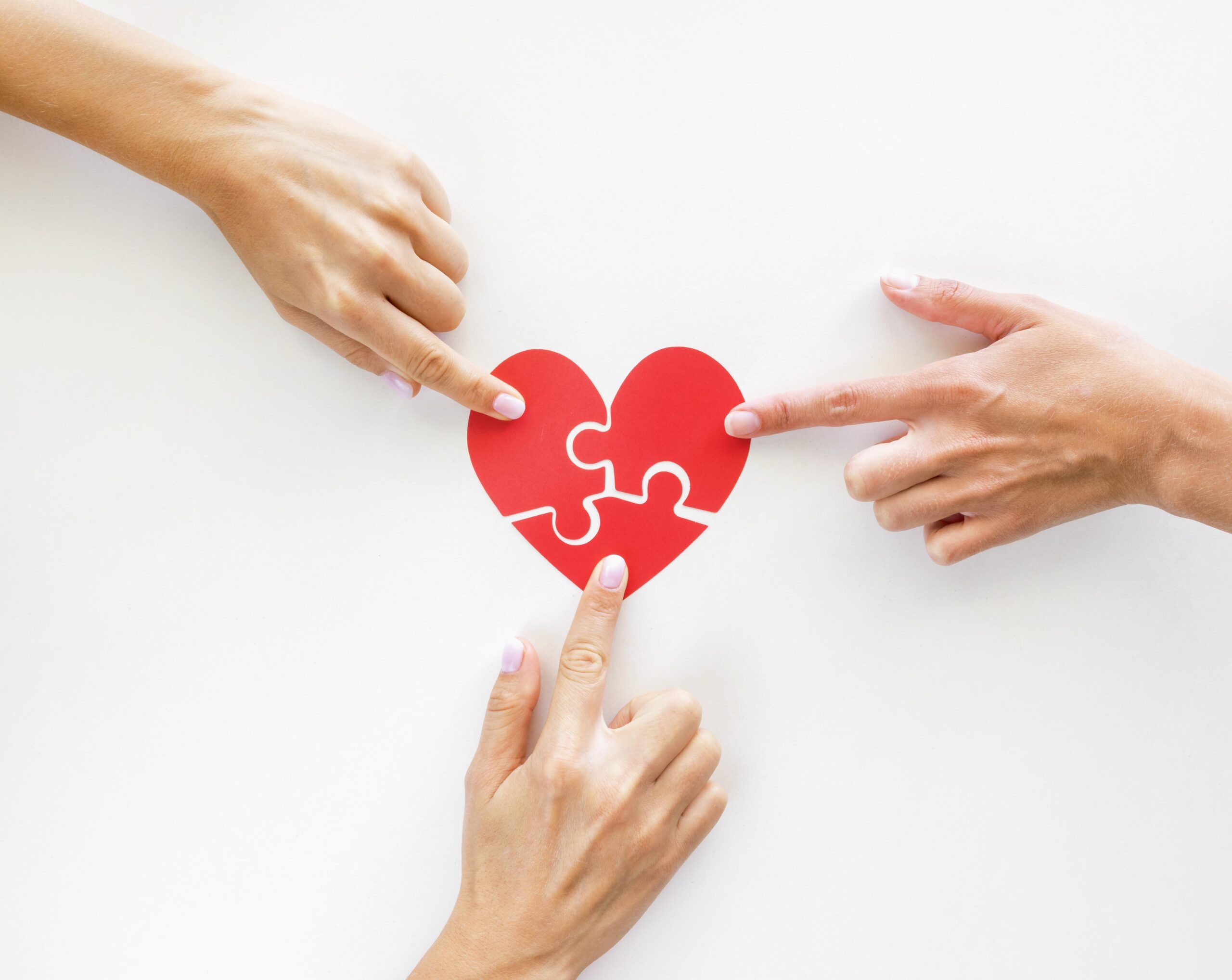 top-view-of-hands-touching-puzzle-heart-pieces