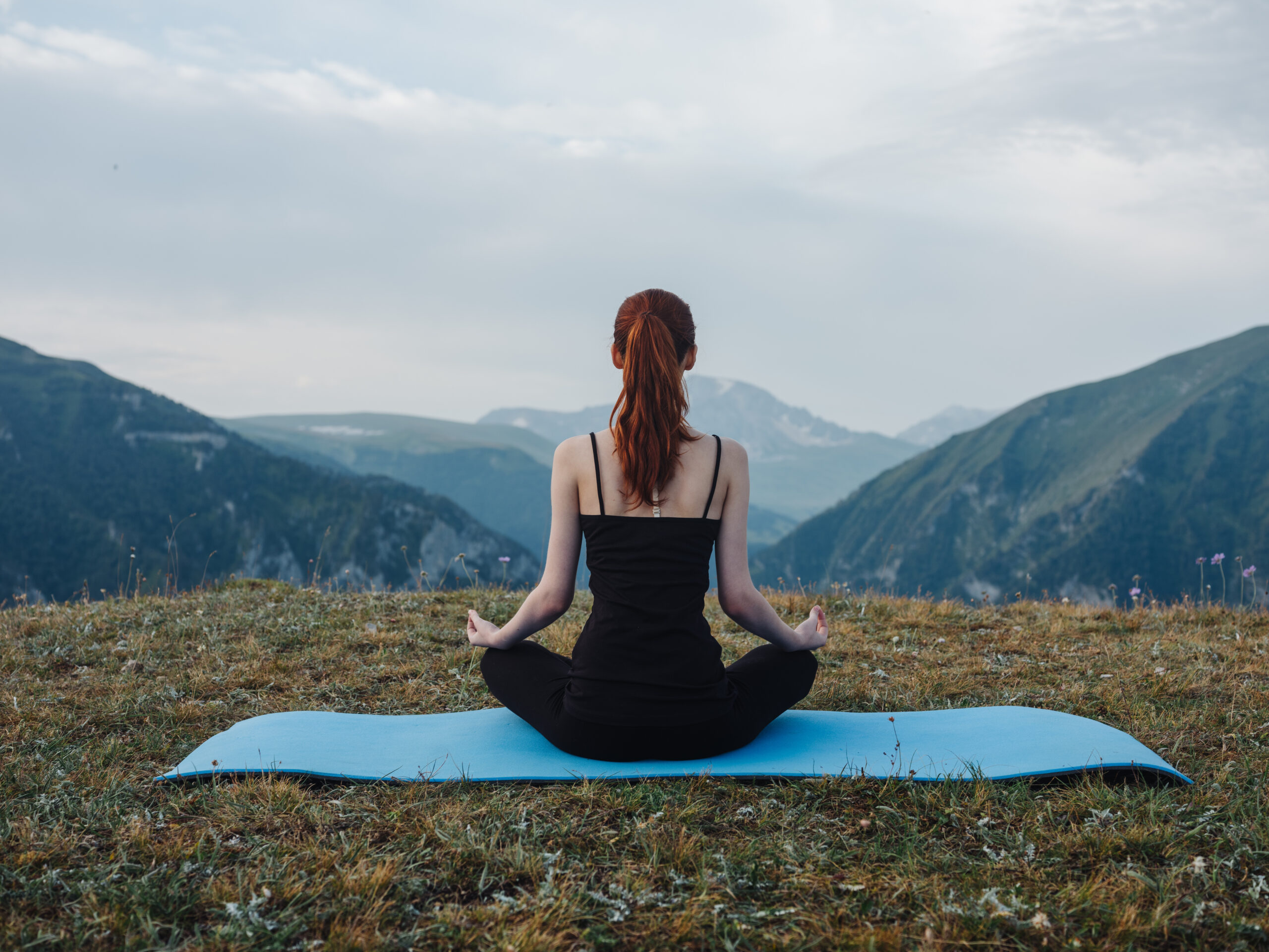 Woman sitting on a mat meditation yoga asana nature fresh air. High quality photo